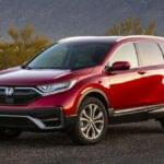 2021 Honda CR-V Hybrid in red with shrubs and cactus in the background.