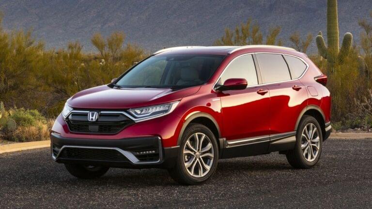 2021 Honda CR-V Hybrid in red with shrubs and cactus in the background.
